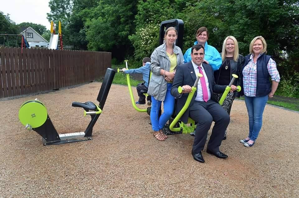 Cllr McDonald trying out the gym equipement with Ahoghill Petition organisers Marlene Drummond, Laura Rainey, Jackie Stewart, and Emma Finnegan